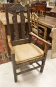 An 18th Century Welsh oak armchair with carved back panels dated 1743 with panelled seat and carved