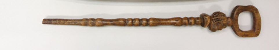 An African carved wooden walking cane decorated with a male figural bust and an embossed card panel