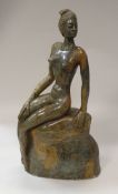 A 20th Century African carved soapstone figure of a nude upon a rock