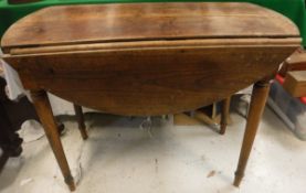 A 19th Century French Provincial cherry wood circular drop leaf dining table on turned tapering