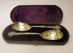 A cased pair of Victorian cast silver fruit spoons with Gothic Revival style decoration to the