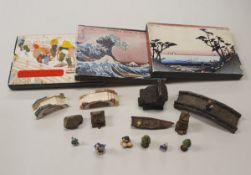 A container of various miniature decorative Japanese figures and ornaments including houses, bridge,