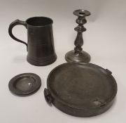 A collection of 18th and 19th Century pewter wares to include two quart measures, four candlesticks,