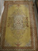 A Turkish rug the central panel set with floral and bird decorated medallion on a yellow ground