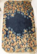 An Art Deco Chinese carpet the dark blue ground with blue, peach and golden floral decorated border,