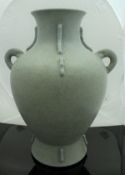 A Chinese matt celadon glazed vase with open work handles and ribbed decoration bearing faux