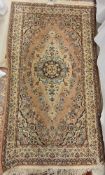 A Persian rug, the central panel set with a floral decorated medallion of a pale pink ground,