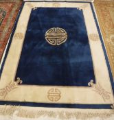 A modern Chinese superwash rug the central panel set with a Chinese symbol on a dark blue ground