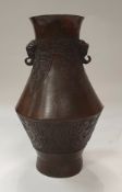 A Chinese bronze vase with scrolling and lotus leaf decoration with elephant head handle,