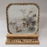 A Japanese porcelain polychrome decorated rectangular tray depicting a family group by waters edge