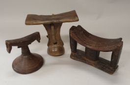 A collection of three African tribal carved wooden headrests