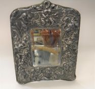 A sterling silver dressing mirror depicting cherubs and maiden within a foliate decoration stamped