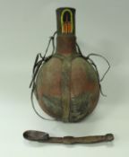 An African tribal carved wooden spoon and a leather mounted gourd shaped water vessel