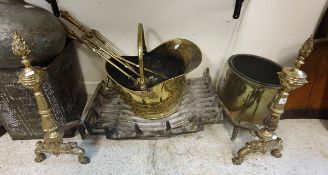 A set of three engraved brass fire irons, brass coal helmet, pair of brass fire dogs,