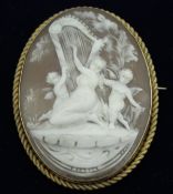 A 9 carat gold mounted cameo brooch depicting classical maiden and cherubs playing a harp in the