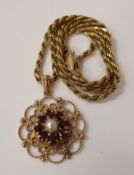 A 9 carat gold garnet and pearl set pendant of stylised floral form housed on a 9 carat gold chain