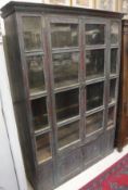 A painted cabinet, the glazed and barred front with two doors enclosing shelving,