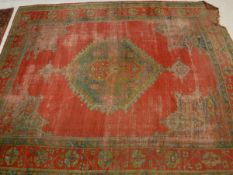 A Turkish carpet the central panel set with lozenge shaped medallion on a red ground within a red,
