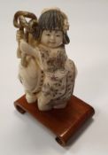 A 19th Century Japanese carved okimono as a young girl riding on the back of an anthropomorphised