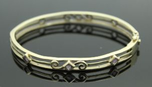A 9 carat gold and amethyst set bangle with pierced decoration in the Victorian style 13 g