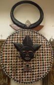 A large goli kplekple wall mask with horned decoration above the main medallion with central mask