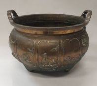 A Chinese bronze tripod censer of large proportions decorated with panels depicting signs of the