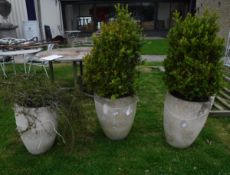 A set of three composite stone garden urns of simple tapered cylindrical form