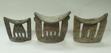 Three similar African carved wooden tribal headrests