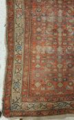 A Persian runner, the central panel set with repeating stylised floral motifs on a red ground,