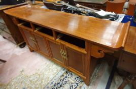 A Chinese cherrywood side cabinet with three drawers over four cupboard doors