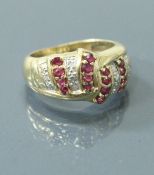 A 9 carat gold dress ring set with bands of multiple diamonds and rubies, ring size L,