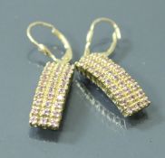 A pair of 9 carat gold earrings of curved form set with pink stones