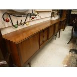 A 1970s teak sideboard with three drawers and three sliding doors raised on tapered supports