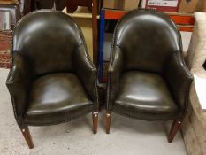 A pair of modern green leather tub chairs raised on square tapering legs