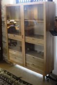 An Ercol display cabinet with two glazed doors enclosing adjustable shelving and six drawers,