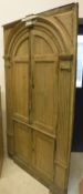 A late Georgian pine corner cupboard with a pair of twin panelled domed doors enclosing two shelves