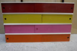 A set of four coloured painted metal storage cabinets with sliding doors