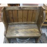 A rustic pine hall seat of pew form on plank end supports