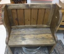 A rustic pine hall seat of pew form on plank end supports