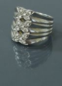 An 18 carat white gold ring set with fifteen diamonds in the form of three crosses, ring size Q,