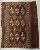 A Bokhara Juval rug, the central panel set with nine repeating medallions on a brown ground,