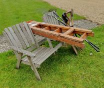 A teak garden two section bench with integral table and a collection of garden tools and a wooden