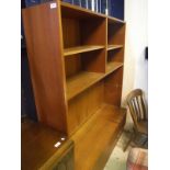 A mid 20th Century teak lounge unit with shelving over two sliding doors designed by Poul Hundevad