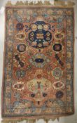 A Caucasian rug, the central panel set with stylised floral motifs on a pale pink ground,