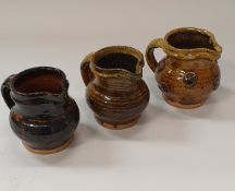 DOUG FITCH - three earthenware cream jugs, impressed seal below handles, 10.