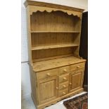 A modern pine dresser with two tier boarded plate rack over three small drawers flanked by two