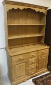 A modern pine dresser with two tier boarded plate rack over three small drawers flanked by two