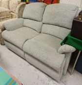 A modern reclining two seat sofa with pale green upholstery