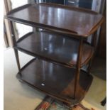 An Ercol elm three tier tea trolley on turned supports to casters