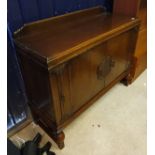 A 1930s oak sideboard with two central cupboard doors enclosing drawers and shelves flanked by two